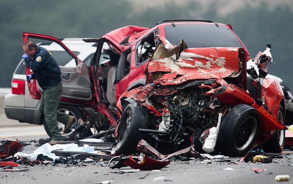 Officials investigate the scene of a multiple vehicle accident where six people were killed on the westbound Pomona Freeway in Diamond Bar, Calif.