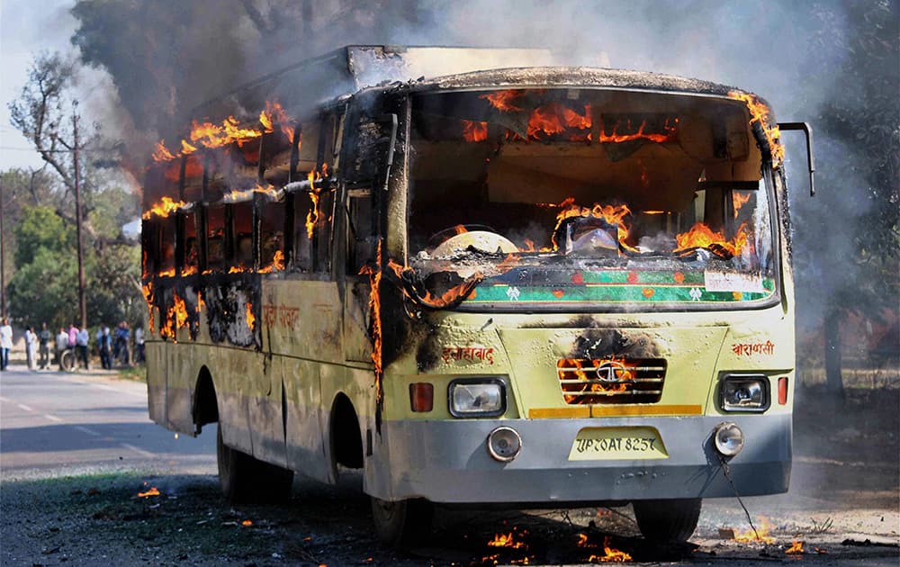 Villagers set ablaze a bus during a protest against a murder of a person during the clashes between two group a day before in Allahabad.