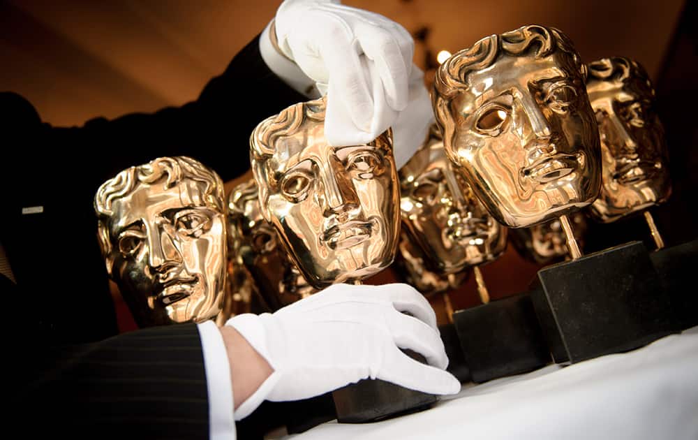 Sean Davoren, an employee from the Savoy Hotel, polishes a BAFTA award in London, ahead of the British Academy of Film and Television Arts Awards on Sunday.