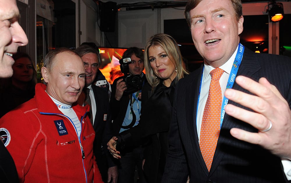 Russian President Vladimir Putin listens to King Willem-Alexander of the Netherlands as Queen Maxima stands in the middle during a visit to the Netherlands house in Sochi, during the 2014 Winter Olympics.
