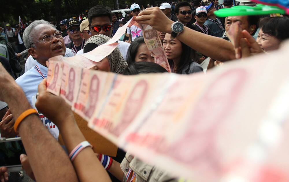 Anti-government protest leader Suthep Thaugsuban collects donation during a march through streets in Bangkok, Thailand.