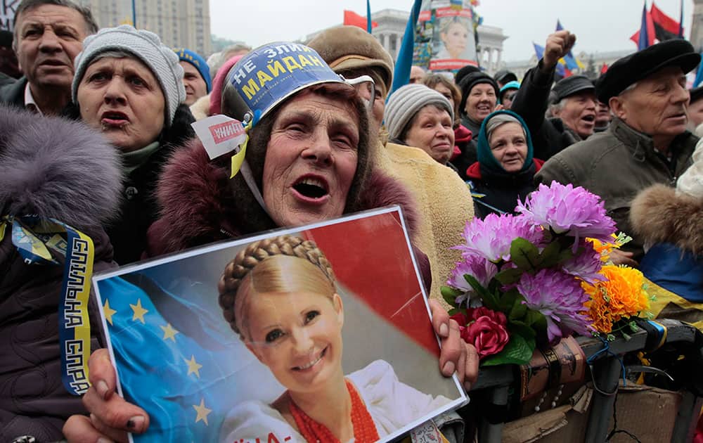 Opposition supporters, one holding a portrait of former prime minister Yulia Tymoshenko shout, slogans during a rally in the Independence Square in Kiev, Ukraine.
