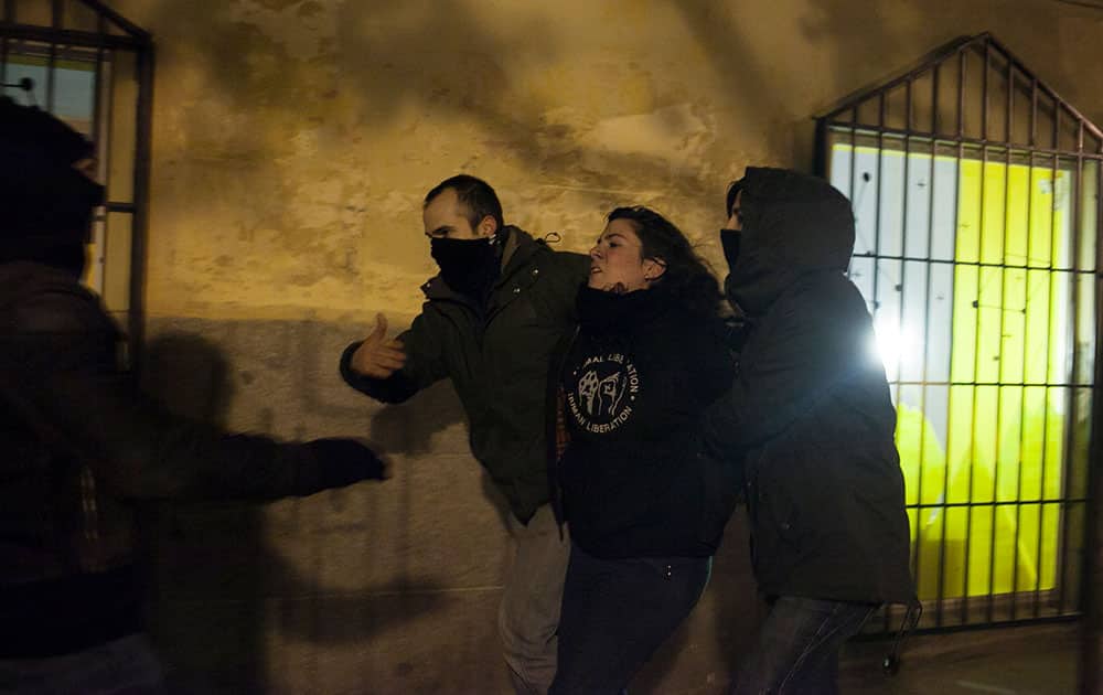 A protester is detained by police in plain clothes after a demonstration against the government in Madrid, Spain.