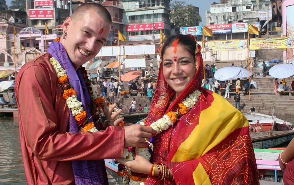A foreign couple getting married according to Hindu traditions on the bank of Ganga River in Varanasi.