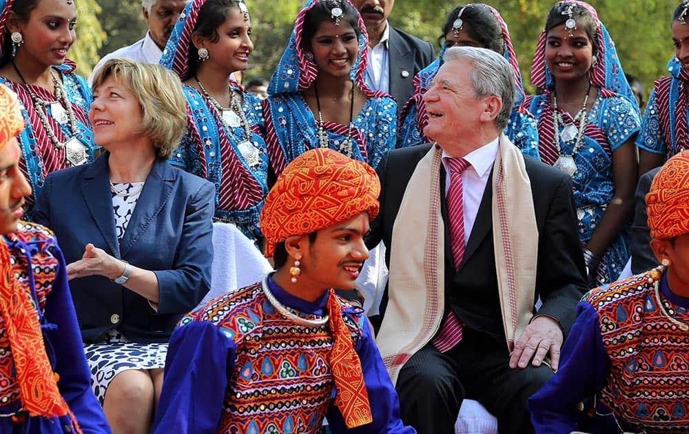 German President Joachim Gauck and his partner Daniela Schadt interact with students wearing traditional attire during an event at government run Kendriya Vidyalaya, or central school, in Bangalore.