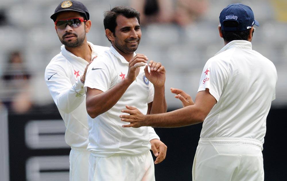 India’s Mohammed Shami, center, celebrates the dismissal of New Zealand’s Peter Fulton for 5 on the third day of the first cricket test, Eden Park in Auckland.