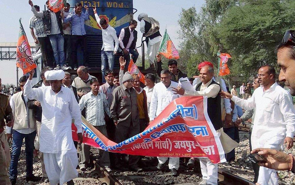 BJP Kisan Morcha activists stop a train at Kanakpura Railway Station during a protest in Jaipur.