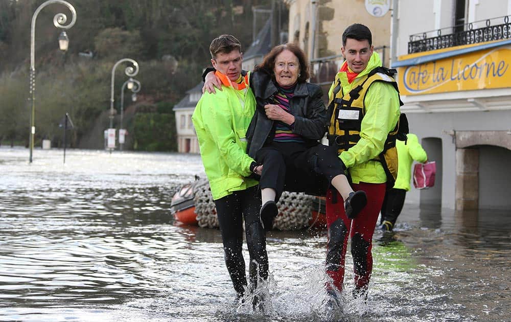 A rescue team help a woman leave her home safely in the centre of Quimperle, western France, which has been flooded by the Laita river.