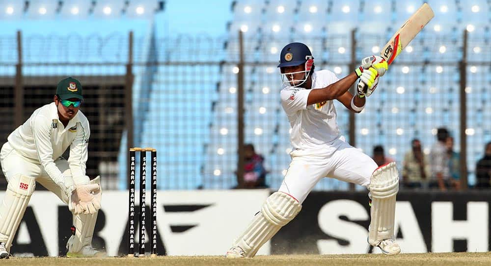 Sri Lanka’s Dinesh Chandimal, right, plays a shot as Bangladesh’s Shamsur Rahman watches on the fourth day of the second test cricket match between them in Chittagong, Bangladesh.
