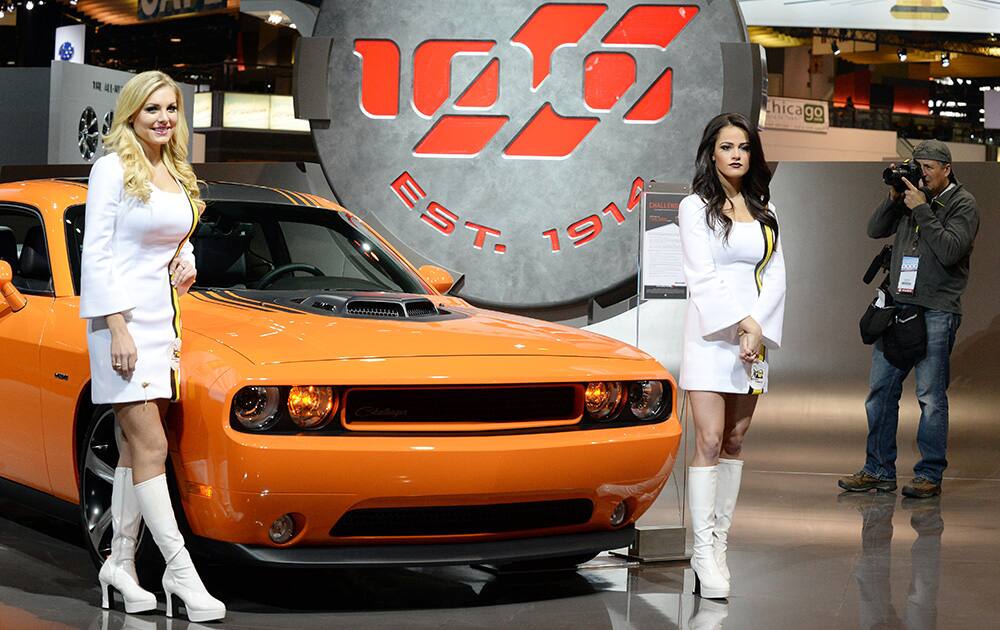 Models stand near a Dodge Challenger on display during the Chicago Auto Show at McCormick Place in Chicago.