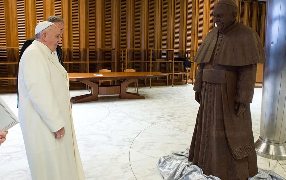 Pope Francis stands in front of a lifesize statue of chocolate of himself. The statue, made with 1.5 tons of cocoa, was presented to the Pope during the general audience.