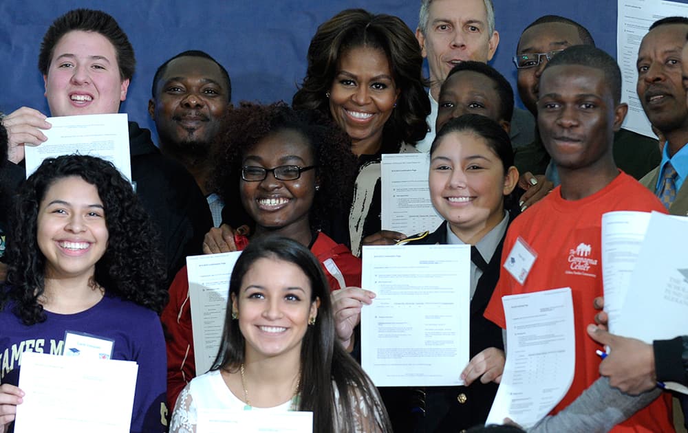 First lady Michelle Obama and Education Secretary Arne Duncan pose for a group photo with students at T.C. Williams High School in Alexandria, Va., following a workshop to help students fill out the Free Application for Federal Student Aid. Mrs. Obama spoke to students and told them that filling out the FAFSA is a pivotal step toward finishing their education beyond high school.