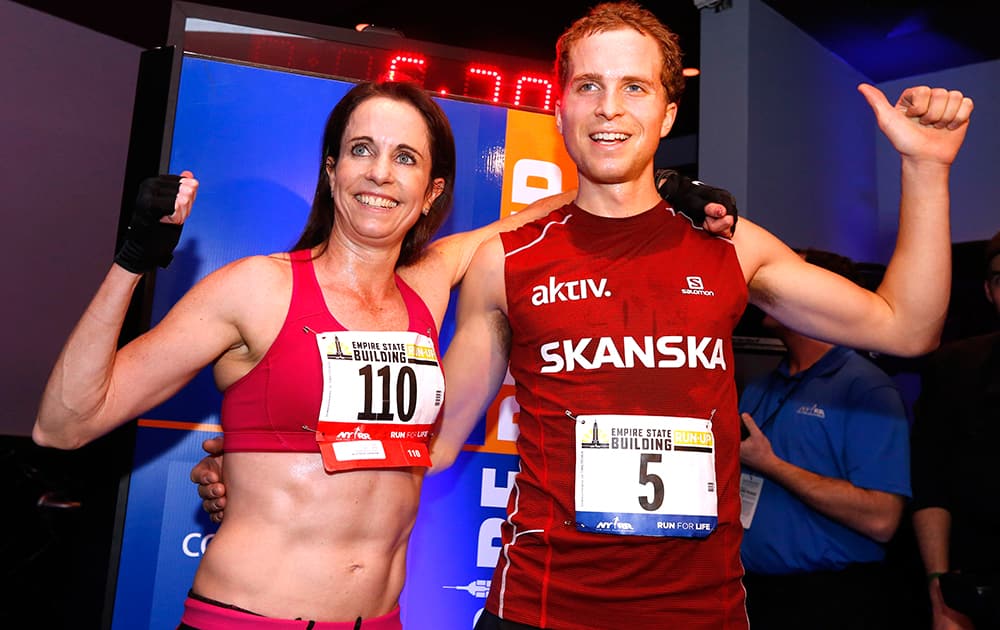 Women`s and men`s division champions Suzy Walsham and Thorbjorn Ludvigsen pose together after the Empire State Building Run-Up, in New York.