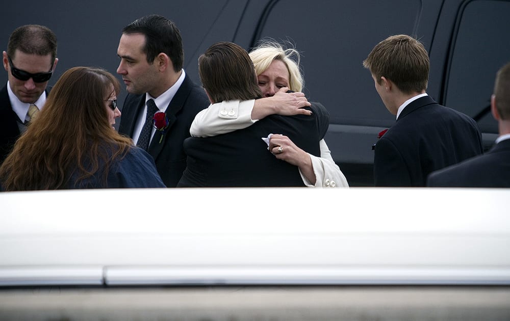 Utah County Sheriff`s Sgt. Cory Wride`s widow Nannette Wride receives a hug from her brother-in-law Ryan Wride after the funeral service for her husband was held at the UCCU Center in Orem, Utah.