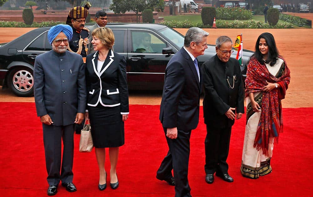 German President Joachim Gauck, walks with Indian President Pranab Mukherjee and Mukherjee`s daughter Sharmistha Mukherjee, as Prime Minister Manmohan Singh, listens to German President`s partner Daniela Schadt during his ceremonial reception at the Presidential Palace in New Delhi.