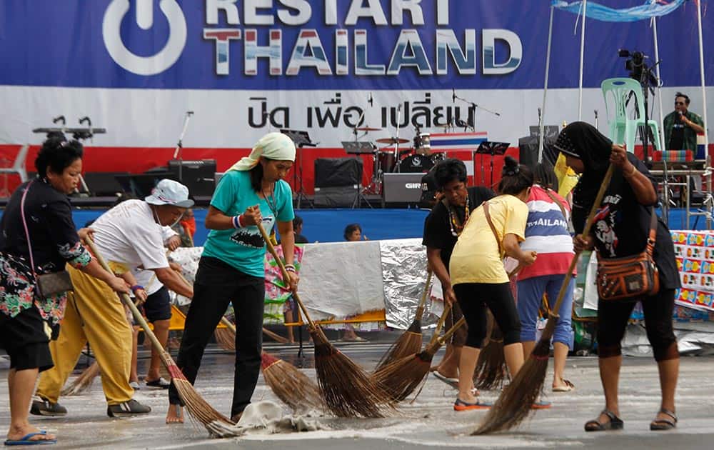 Volunteer street cleaners brush the main anti-government protest site with detergent and brooms in Bangkok, Thailand.