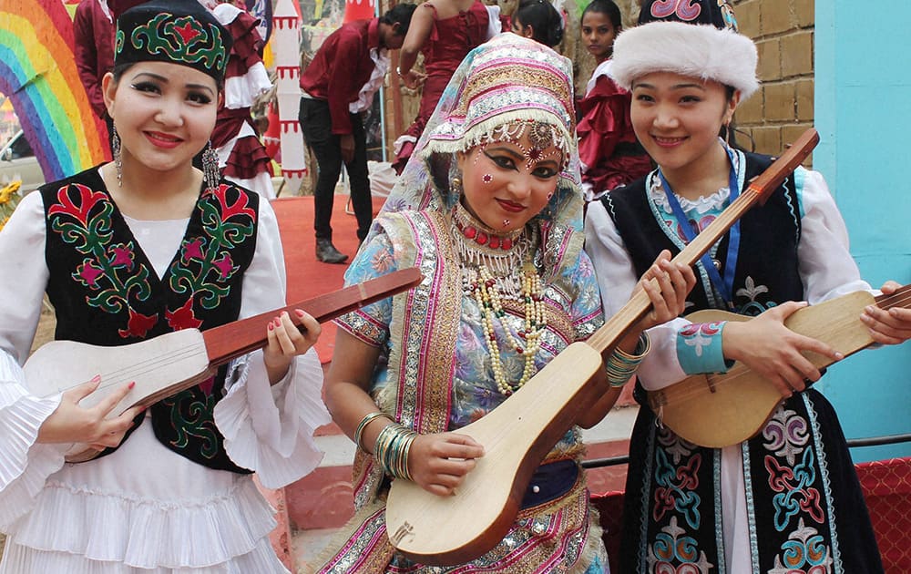 Kyrgyzstani artists pose for photograph with a Braj artist during 28th Surajkund International Crafts Mela in Faridabad.