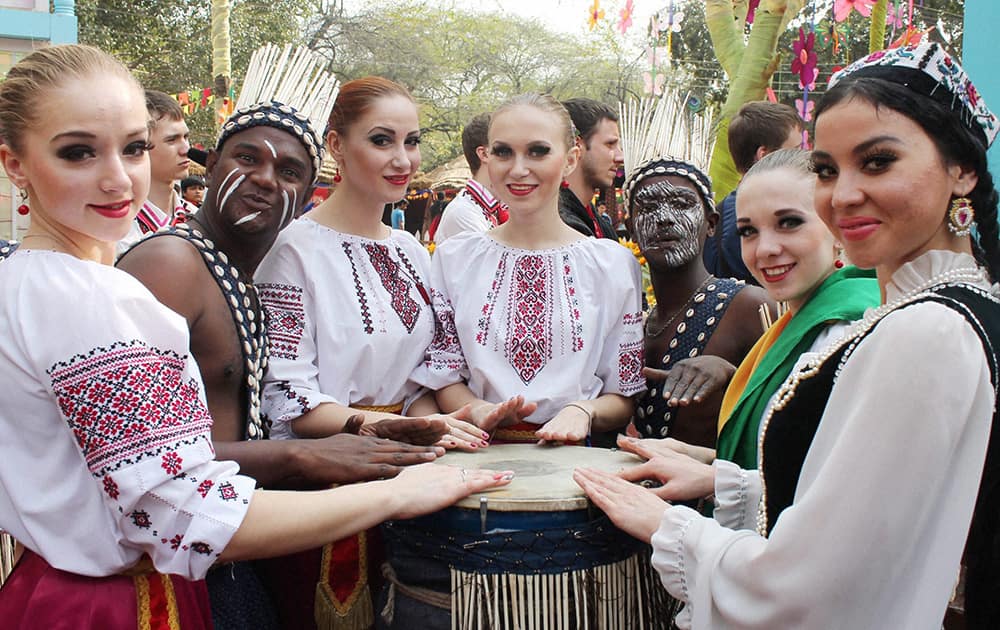 Russian artists pose for photograph with Gujarat`s Siddi Goma artists during 28th Surajkund International Crafts Mela in Faridabad .