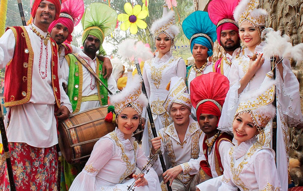 Uzbekistani artists pose for photograph with Panjab artists during 28th Surajkund International Crafts Mela in Faridabad.