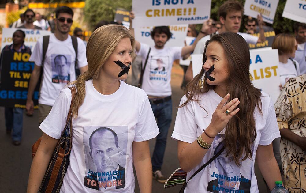 Members of the media march with black tape across their mouths, signifying the silencing of the media, and wearing tee-shirts showing detained Al-Jazeera journalist Peter Greste, at a demonstration by Kenyan and Nairobi-based foreign media calling for the release of Greste and his colleagues, outside the Egyptian embassy in Nairobi, Kenya.
