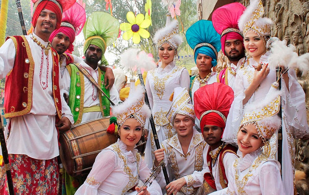 Uzbekistani artists pose for photograph with Panjab artists during 28th Surajkund International Crafts Mela in Faridabad.