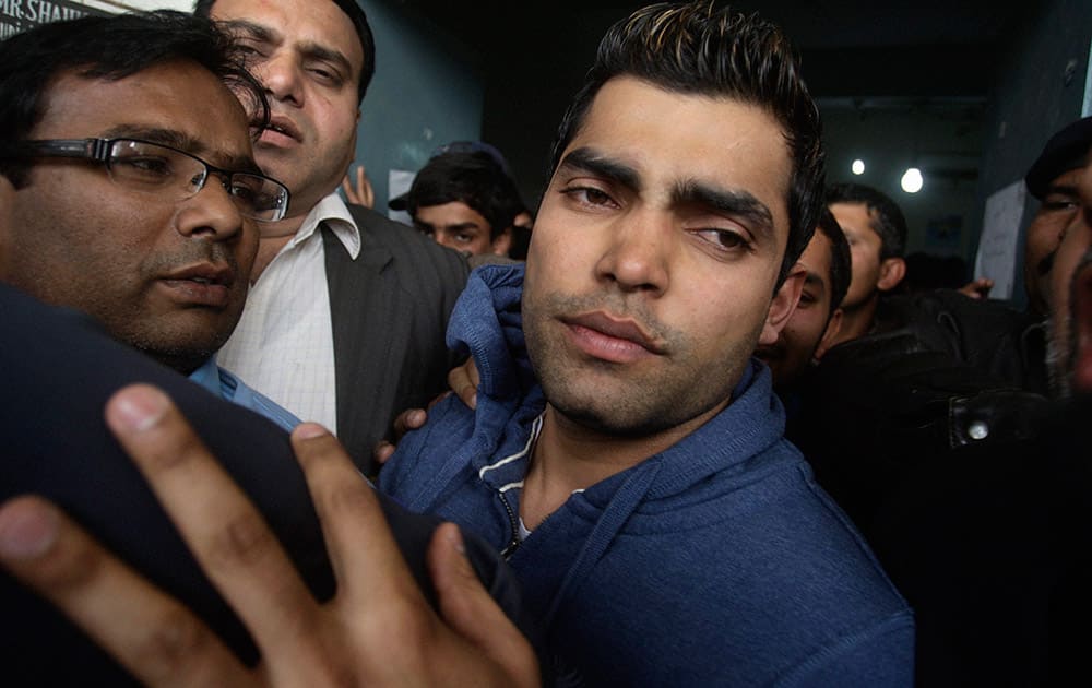 Pakistani cricketer Umar Akmal trys to avoid the media as he leaves as he leaves a court after being granted bail in Lahore. Pakistan cricketer Umar Akmal was released late Saturday after a police official filed for the middle-order batsman`s bail-out for his run-in with a traffic sergeant.