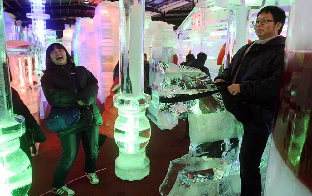 A visitor rides on an ice sculpture of horse as his friend laughs at the Fantasy Ice World in Taipei, Taiwan, on the third day of the Chinese Lunar New Year.
