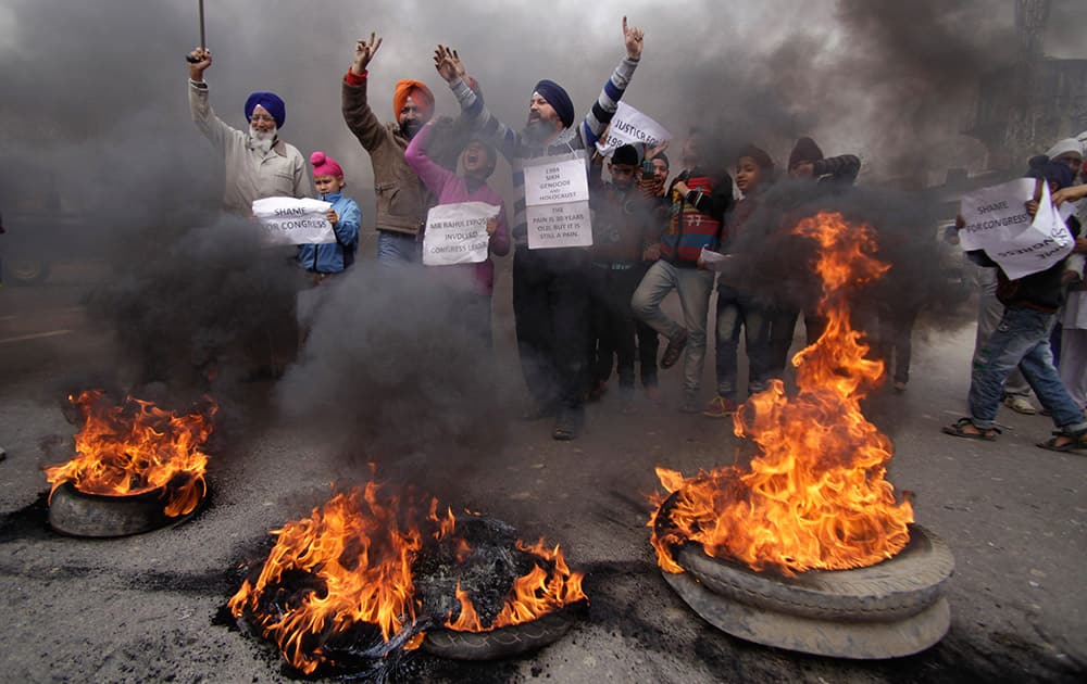 Sikh protestors shout slogans and burn tires during a protest against Congress party leader Rahul Gandhi for his recent remark on the country`s 1984 anti-Sikh riots, in Jammu, India.