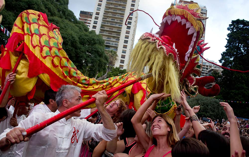 People try to touch the image of a Dragon during a parade on the second day of the Chinese Lunar New Year, marking the year of the horse, in Buenos Aires, Argentina.