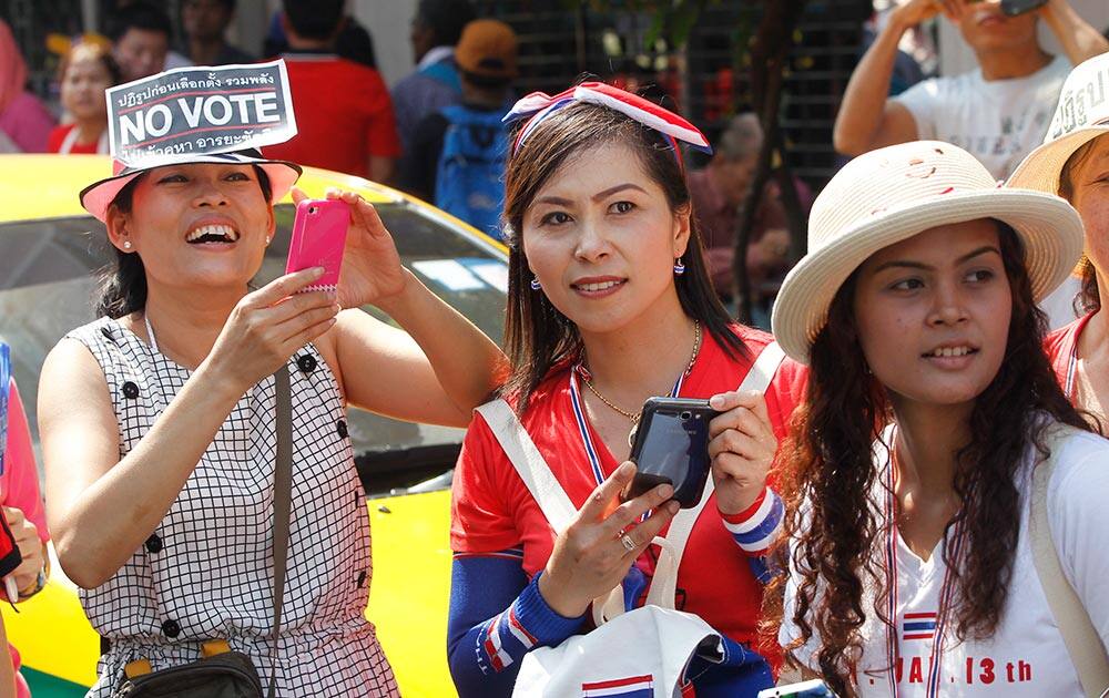 Anti-government protesters wait to see protest leader Suthep Thaugsuban march through the streets of the Chinatown area of Bangkok.