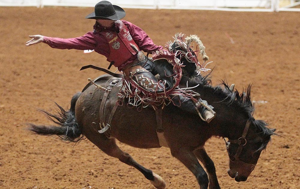 Spencer Wright, of Milford, Utah, rides Gangsta to a score of 62 in the saddle bronc competition in the World`s Original Indoor Rodeo in Fort Worth, Texas.