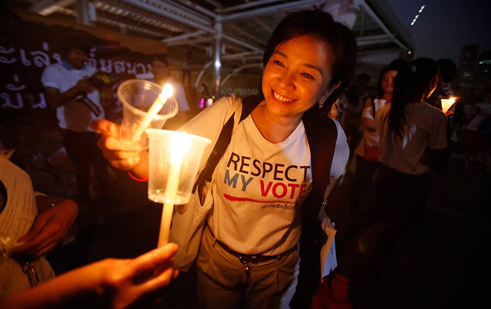 Members of Thailand`s `White Shirt` movement light candles during a vigil to demand democratic elections and political reforms in Bangkok, Thailand.