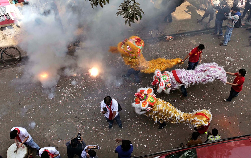 Chinese lion dance participants of Indian origin perform amid exploding fire crackers on Chinese New Year celebrations in Kolkata.