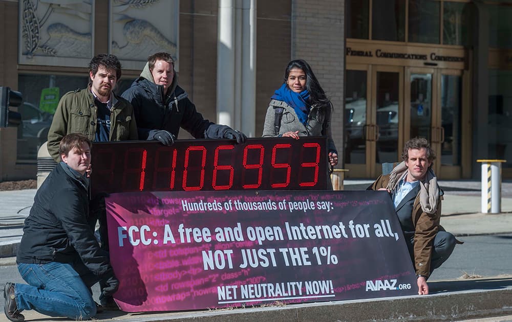 Members of global advocacy group Avaaz stand next to a digital counter showing the number of petition signatures calling for net neutrality outside the Federal Communication Commission in Washington.
