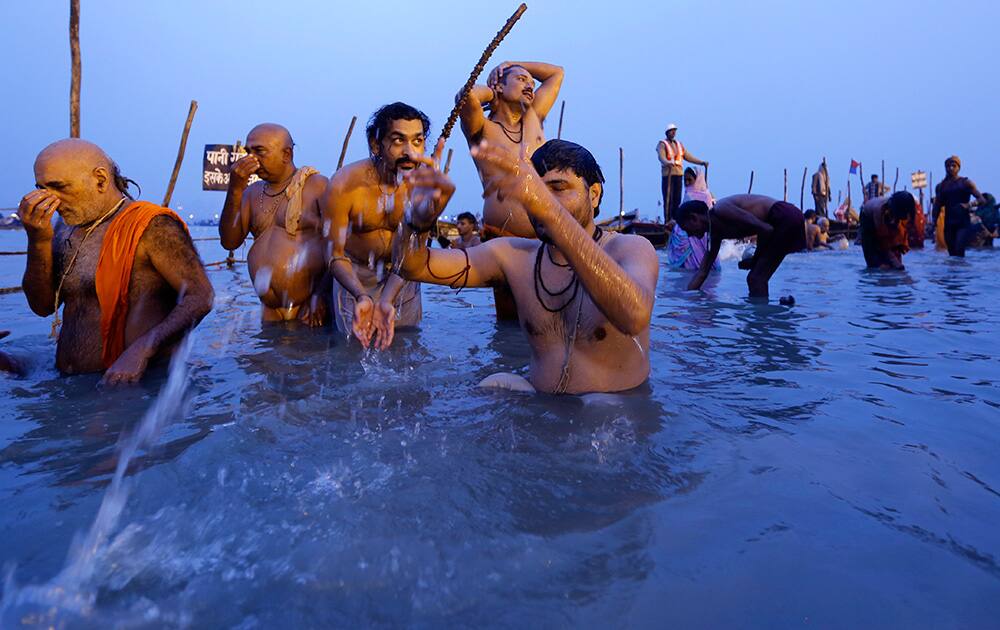 Hindu devotees offers prayers to the Sun god after taking a holy dip at the Sangam, the confluence of the Ganges and Yamuna rivers, on `Mauni Amavasya` or new moon day, the third and most auspicious date of bathing during the annual month long Hindu religious fair `Magh Mela` in Allahabad.