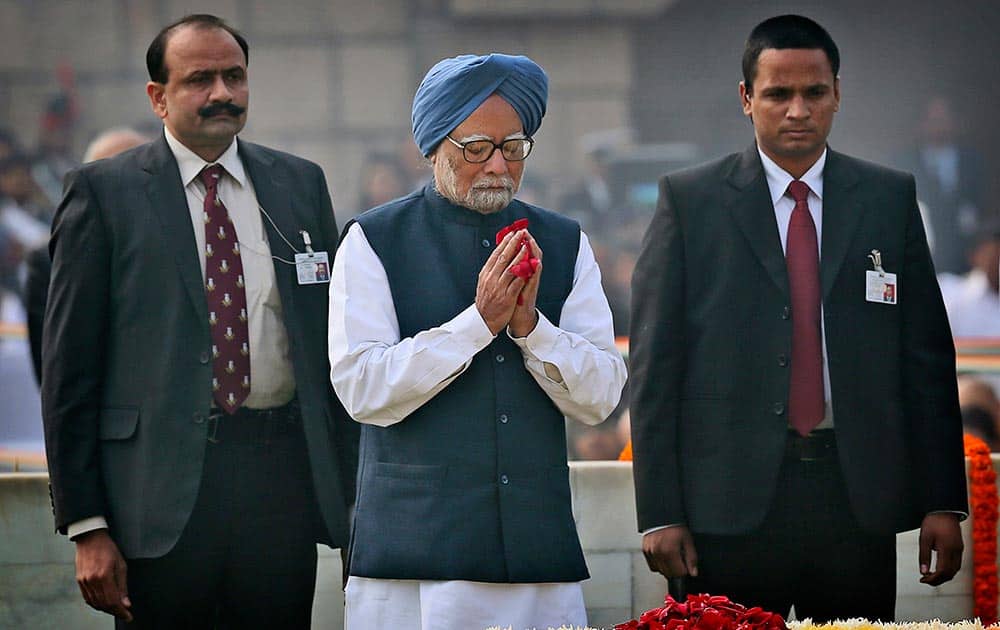 Prime Minister Manmohan Singh, center, pays floral tributes at Rajghat, the memorial of Mahatma Gandhi, on his death anniversary in New Delhi.