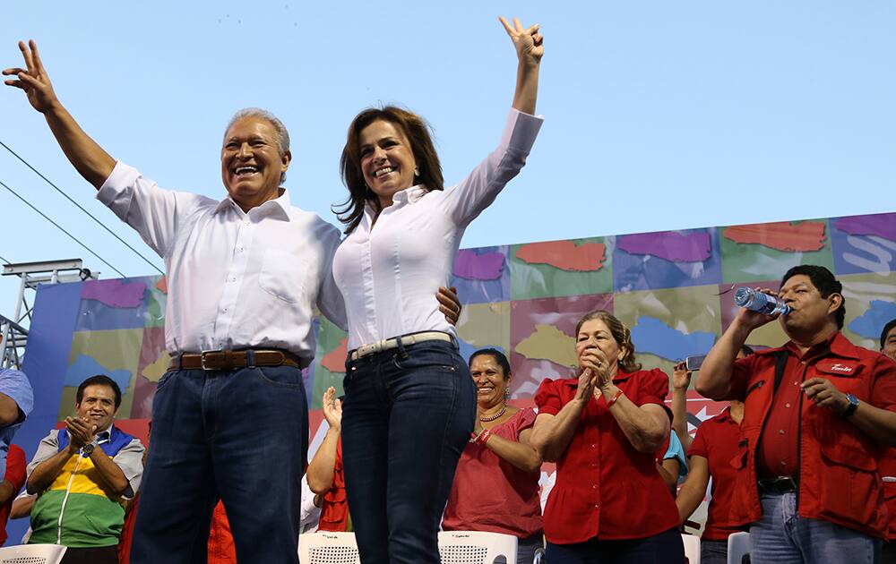 Vice President Salvador Sanchez Ceren presidential candidate of the ruling Farabundo Marti National Liberation Front, waves to supporters accompanied by first lady Vanda Pignato, during the closing of his campaign in Soyapango, El Salvador.