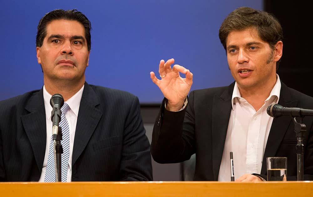 Argentina`s Cabinet Chief Jorge Capitanich, left, and Argentine Economy Minister Axel Kicillof, right, speak to the media during a press conference in Buenos Aires, Argentina.