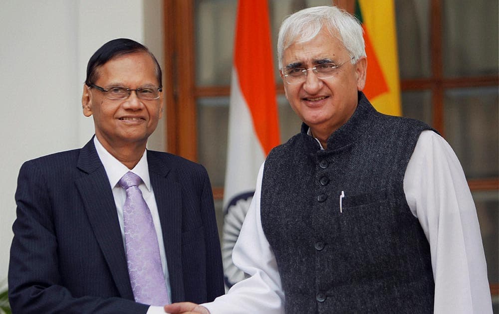 External Affairs Minister Salman Khurshid shakes hands with his Sri Lankan counterpart Gamini Lakshman Peiris in New Delhi.