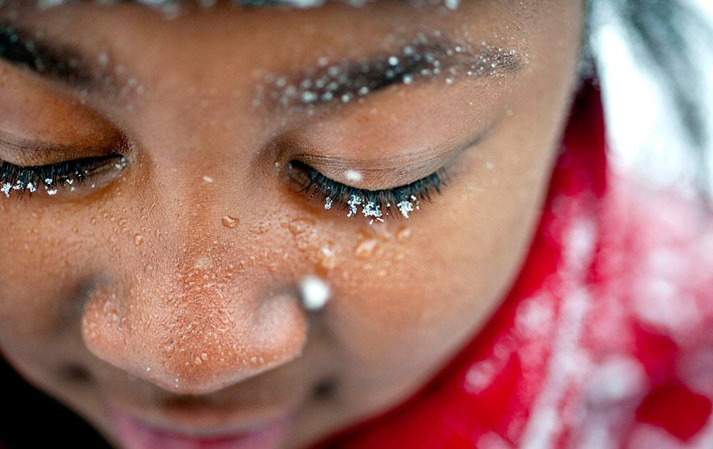 Snowflakes cling to nine-year-old Tamya Hardy`s eyelashes as she plays in the snow with friends, in Winston-Salem, N.C.