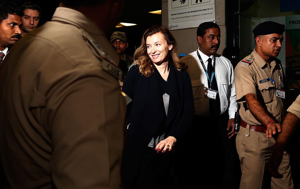 France`s former first lady Valerie Trierweiler, centre, smiles as she arrives at the airport to board a flight in Mumbai, India.