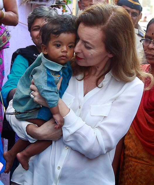 France`s former first lady Valerie Trierweiler cuddles a baby during her visit to a slum in Mumbai.