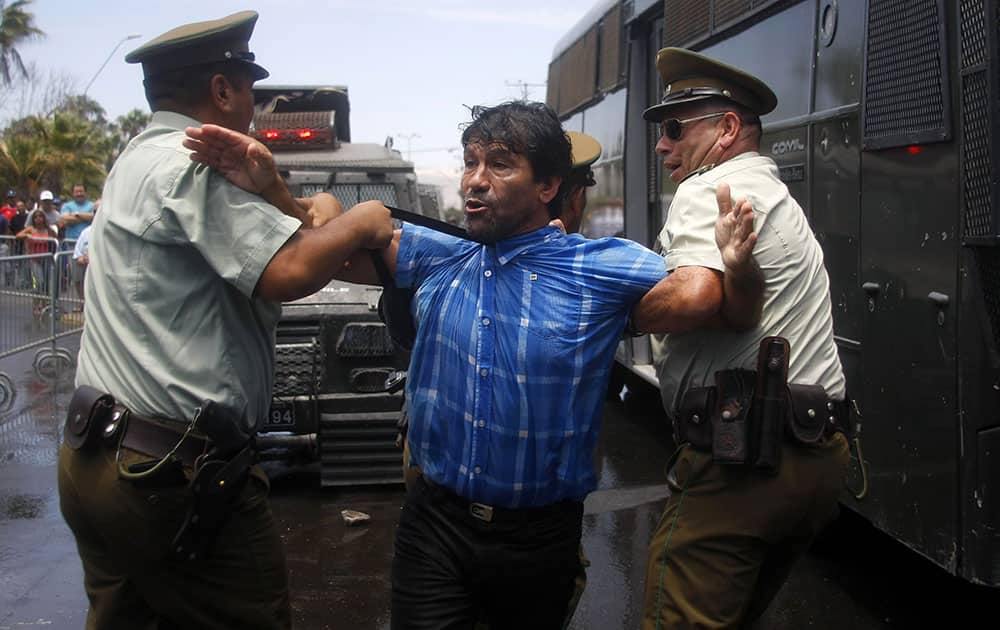 A man protesting the United Nations` highest court ruling on a maritime boundary between Peru and Chile, is detained by police outside a military installation, in Arica, Chile.