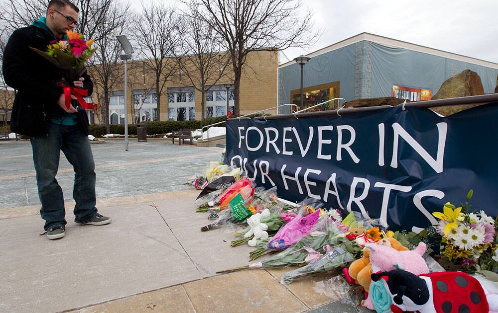 Paul D. Malcolm a friend of one of the victims at the shooting at The Mall in Columbia, Md, place a base with flowers, after The mall was re-open to the public.
