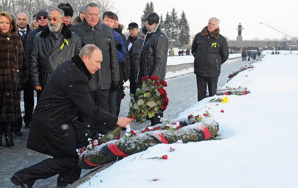 Russian President Vladimir Putin takes part in a wreath laying ceremony at the Piskaryovskoye Cemetery where most of the Leningrad Siege victims were buried during World War II, in St.Petersburg, Russia.