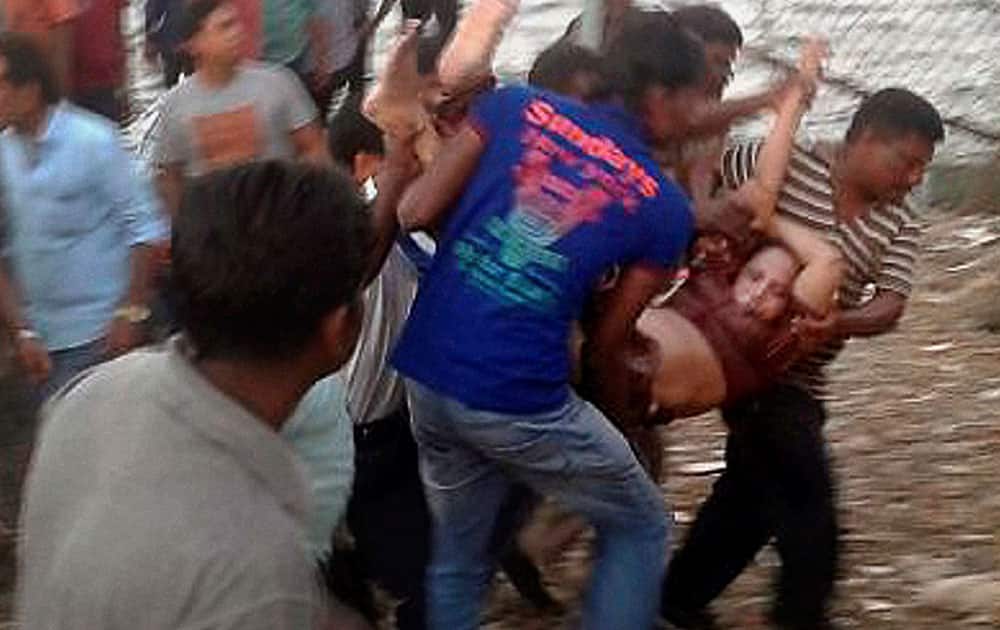 Rescuers carry a woman after a boat capsized off the Andaman and Nicobar islands, India. Police said the tourist boat was overcrowded and may have hit a rock before it went down.