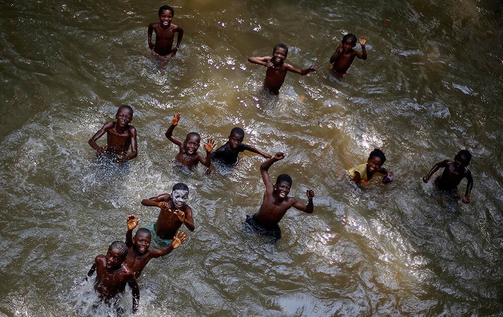 Children swimming in a river near the Central African village of Bobangui, some 50 mms (30 miles) south-west of the capital Bangui, in an area controlled by anti Balaka Christian militias, wave and smile at the photographer.
