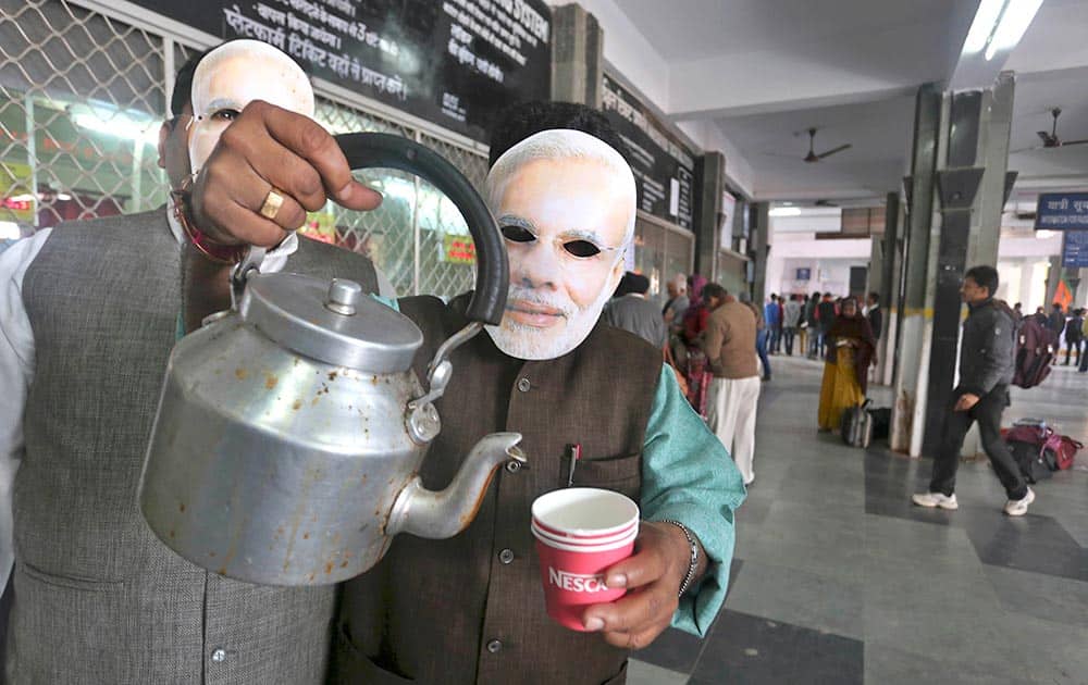 India’s opposition Bharatiya Janata Party (BJP) workers wearing paper masks of their Prime Ministerial candidate Narendra Modi, sell tea at a railway station as part of their campaign for the upcoming parliamentary elections in Bhopal.