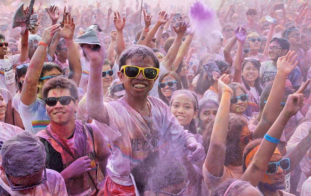 Participants cheer as they throw colored powder into the air during the Color Run in Jakarta, Indonesia.