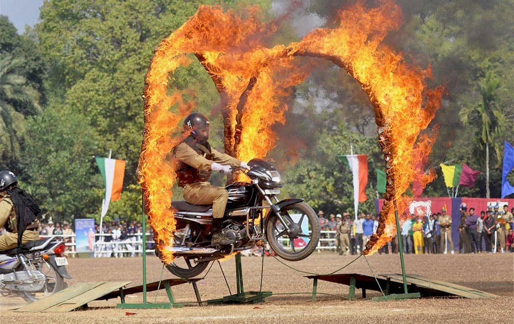 Paramilitary security personnel performs a stunt on a motorcycle during 65th Republic Day parade in Agartala .